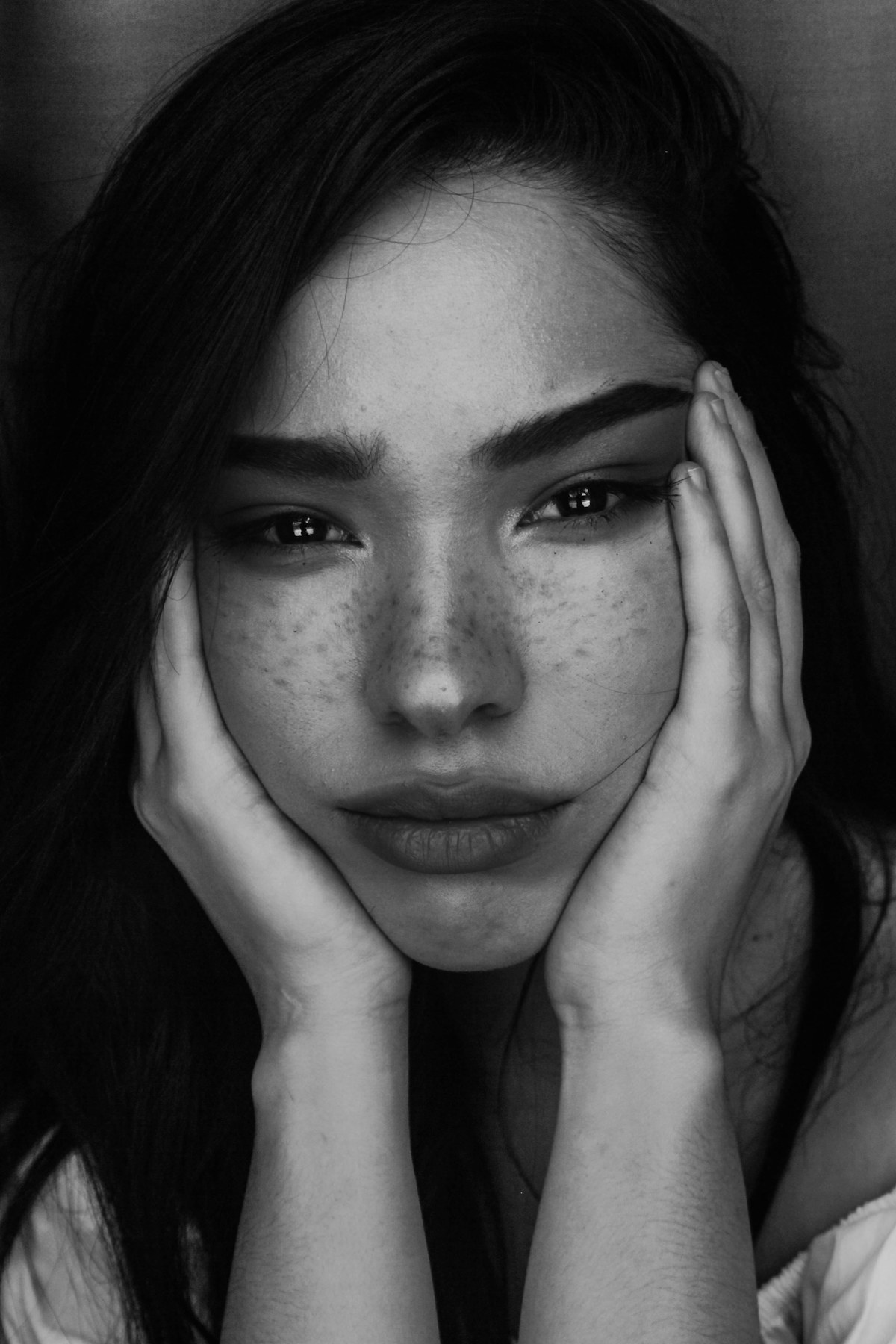 Retrato en blanco y negro con las manos en el rostro